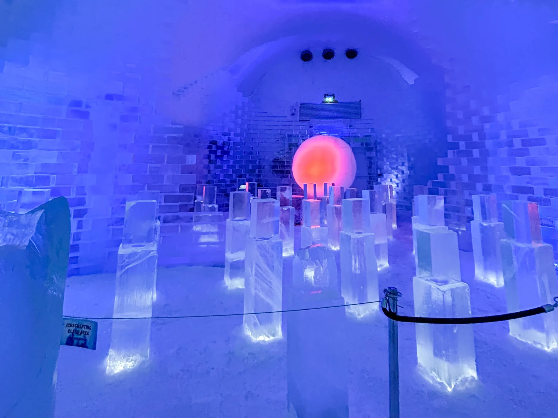 Icebar hall with backlit ice sculptures and red orb